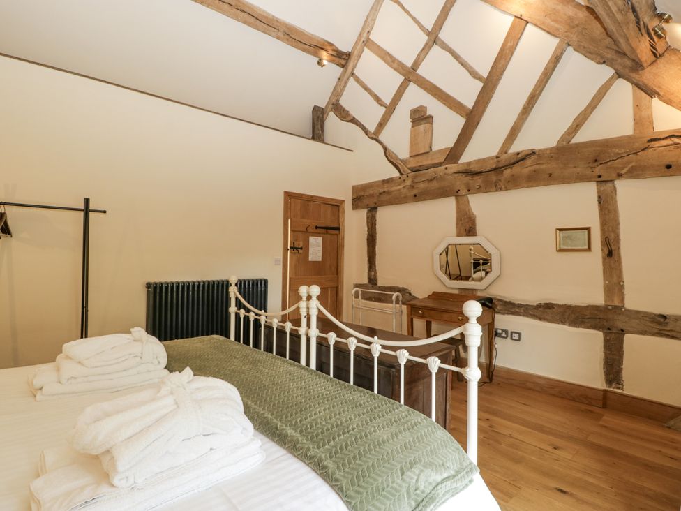 A bedroom with a bed and wooden beams at Evenjobb Court Farmhouse Evenjobb near Presteigne