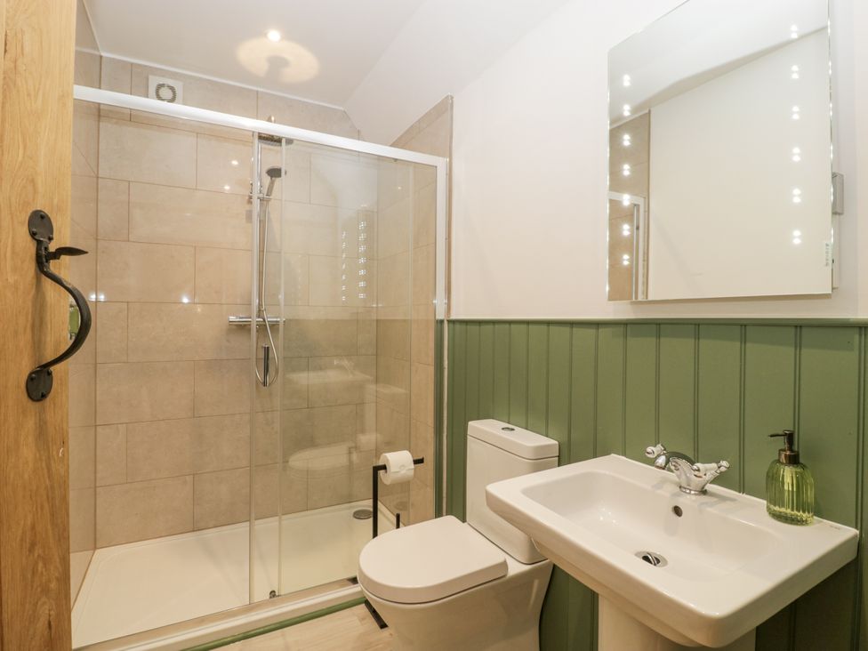 A bathroom with a shower, toilet, and sink at Evenjobb Court Farmhouse near Presteigne