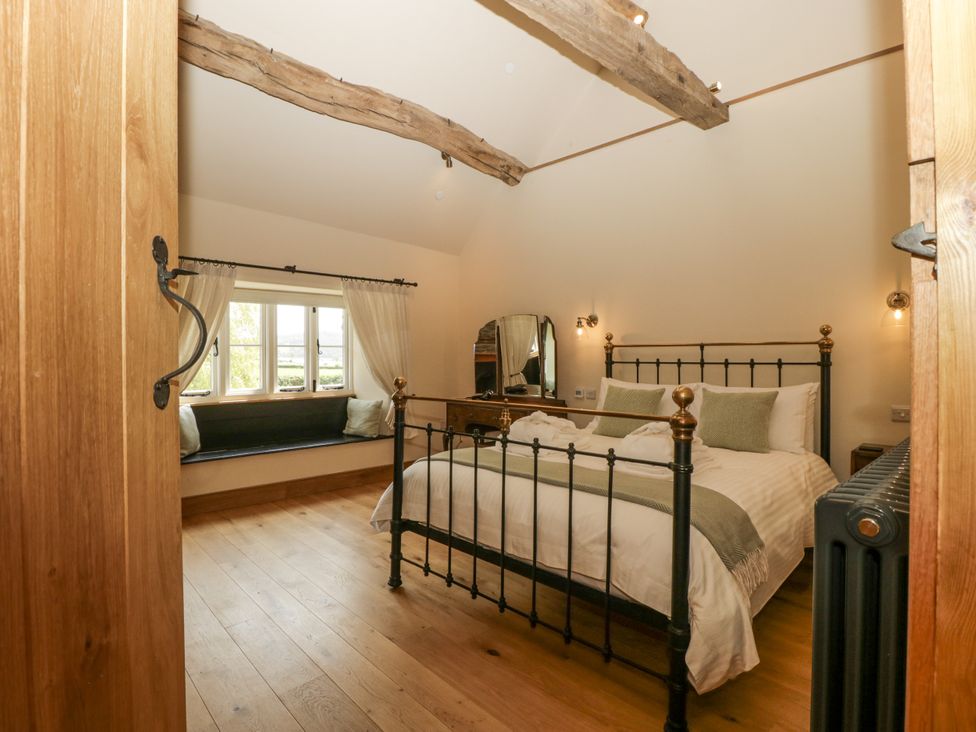 A bedroom with a bed and a sitting area at Evenjobb Court Farmhouse Evenjobb near Presteigne