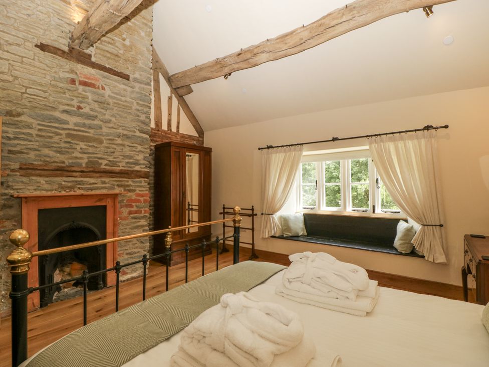 A bedroom with a bed and a window seat at Evenjobb Court Farmhouse Evenjobb near Presteigne