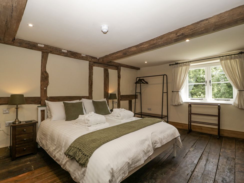 A bedroom with a bed and a window at Evenjobb Court Farmhouse Evenjobb near Presteigne