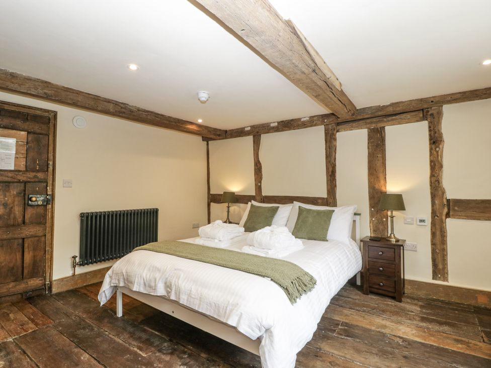 A bedroom with a double bed and wooden beams at Evenjobb Court Farmhouse Evenjobb near Presteigne