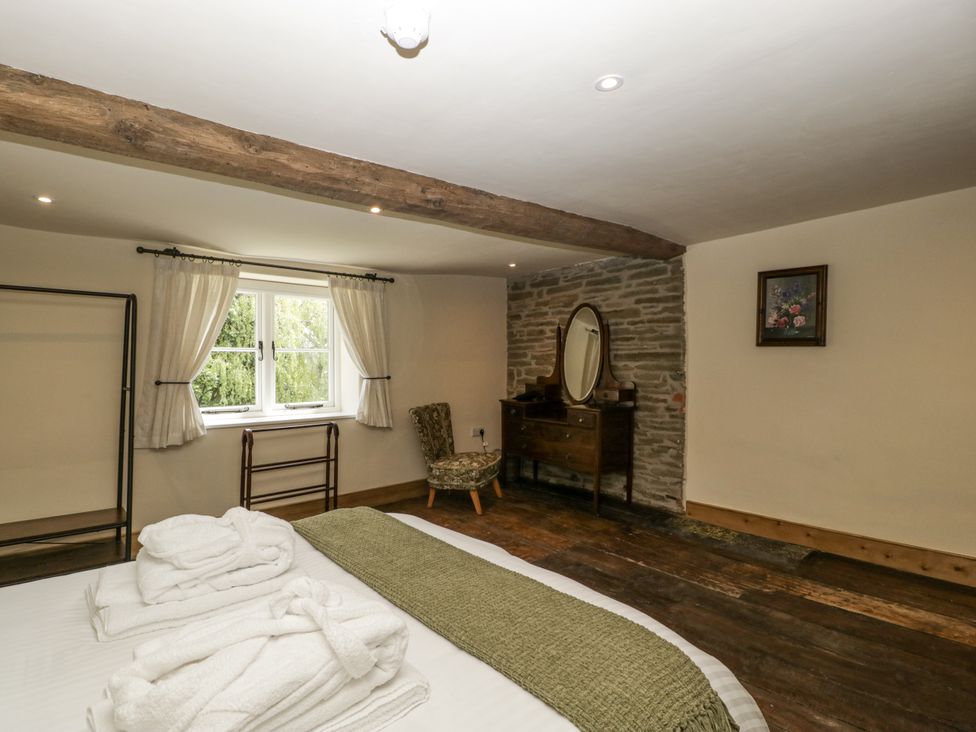 A bedroom with a bed and dresser at Evenjobb Court Farmhouse in Evenjobb near Presteigne