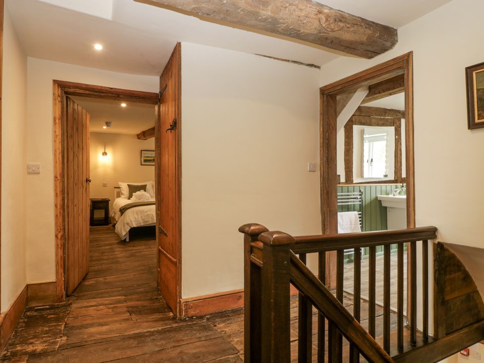 A hallway with doors leading to a bedroom and bathroom at Evenjobb Court Farmhouse near Presteigne