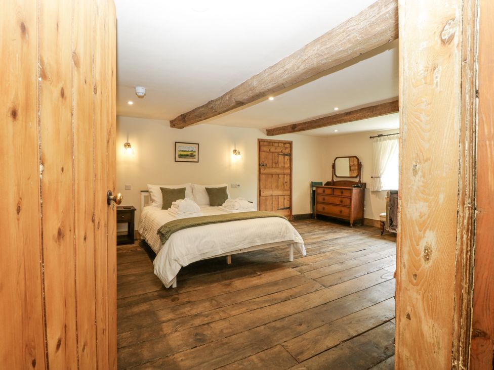 A bedroom with a bed and dresser at Evenjobb Court Farmhouse in Evenjobb near Presteigne