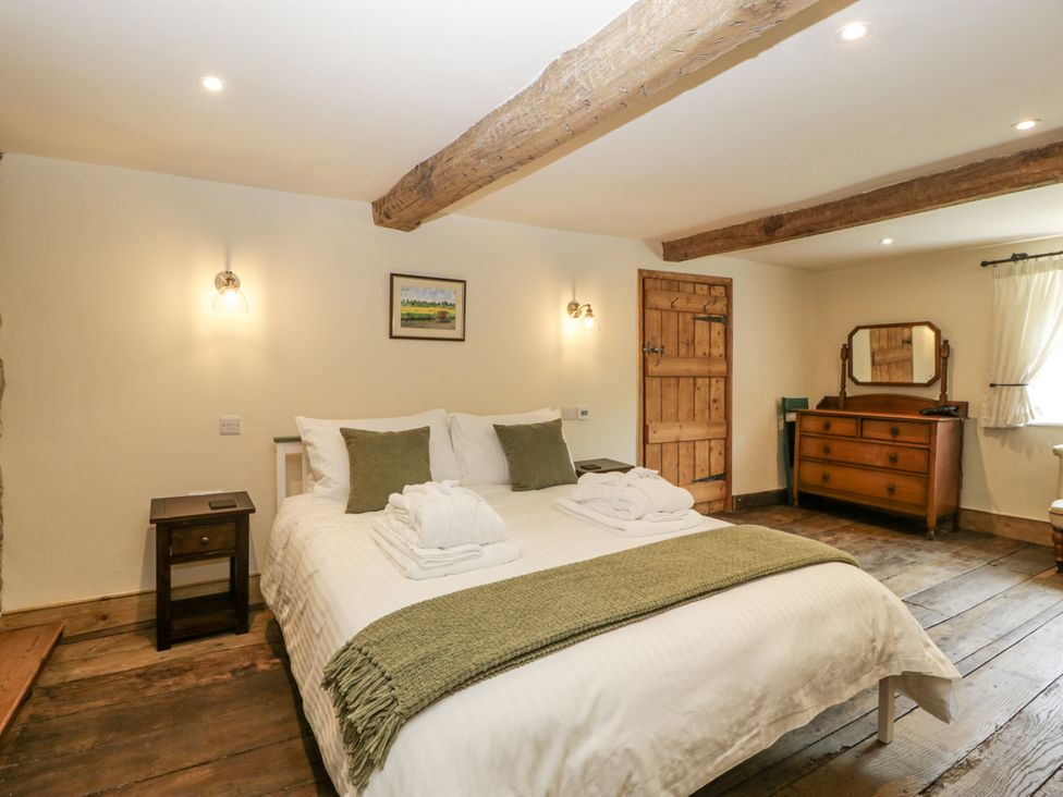 A bedroom with a bed and nightstand at Evenjobb Court Farmhouse Evenjobb near Presteigne