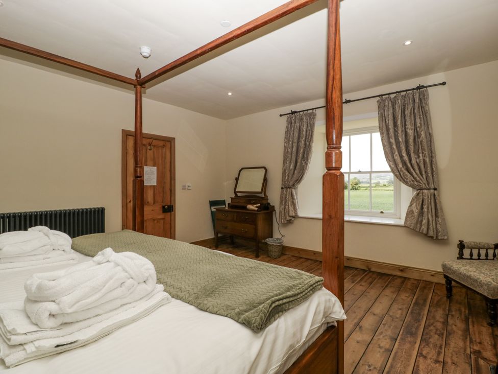 A bedroom with a bed and dresser at Evenjobb Court Farmhouse Evenjobb near Presteigne