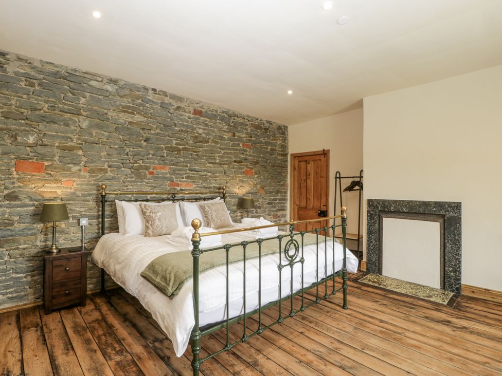 A bedroom with a bed and bedside table at Evenjobb Court Farmhouse near Presteigne