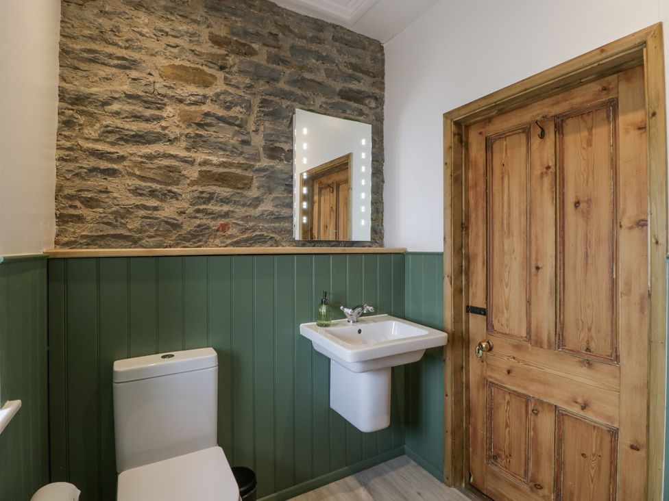 A bathroom with a toilet and sink at Evenjobb Court Farmhouse near Presteigne