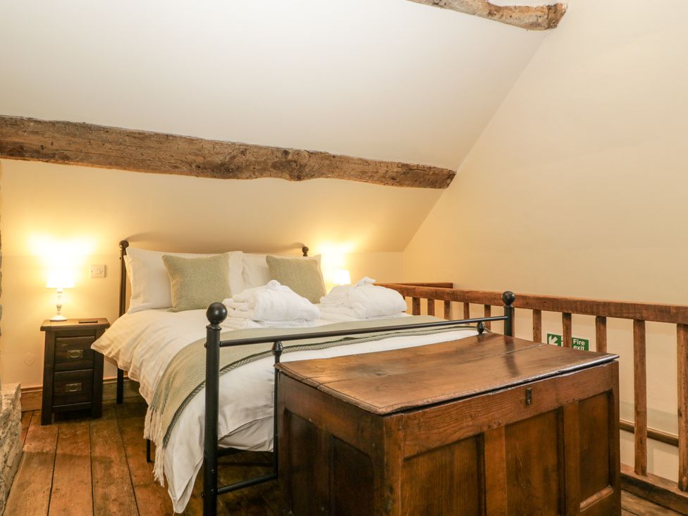 A bedroom with a bed and a wooden trunk at Evenjobb Court Farmhouse Evenjobb near Presteigne