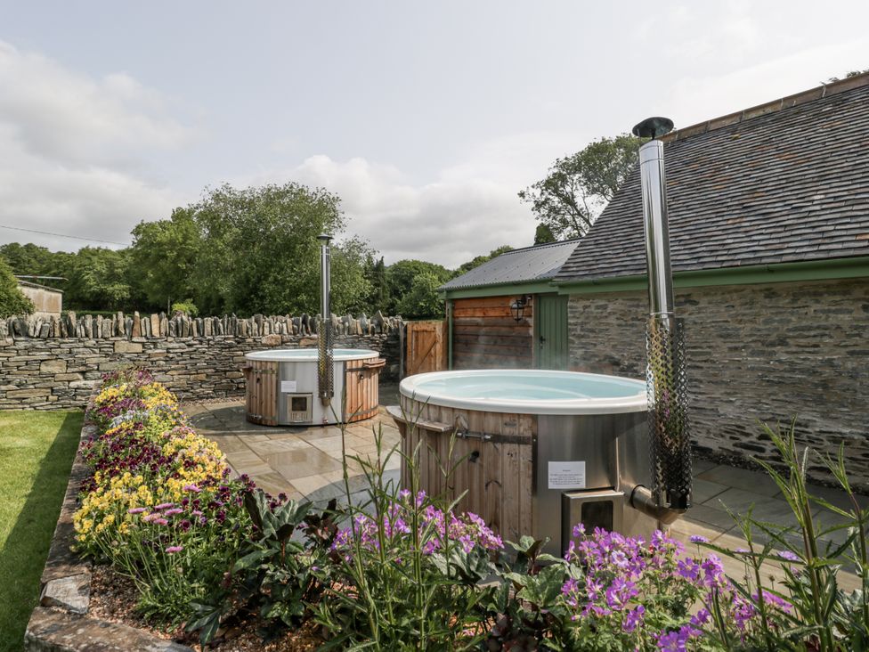 A garden with hot tubs and flowers at Evenjobb Court Farmhouse Evenjobb near Presteigne