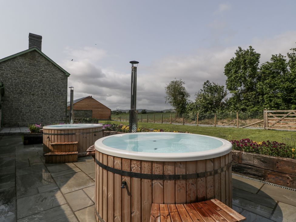 Two hot tubs on a patio at Evenjobb Court Farmhouse near Presteigne