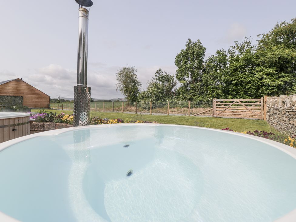 A hot tub with a chimney in the garden at Evenjobb Court Farmhouse near Presteigne