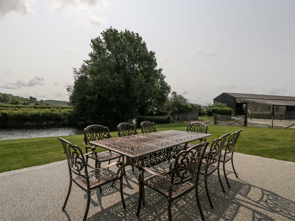 An outdoor seating area with a table and chairs at Evenjobb Court Farmhouse Evenjobb near Presteigne