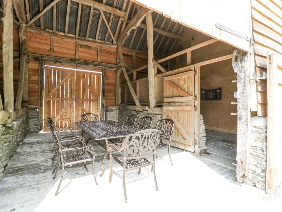An outdoor seating area with a table and chairs at Evenjobb Court Farmhouse near Presteigne