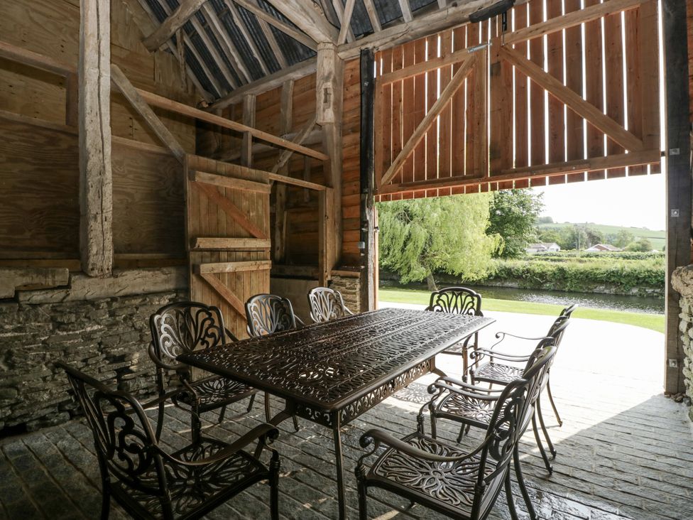 An outdoor dining area with a table and chairs at Evenjobb Court Farmhouse Evenjobb near Presteigne