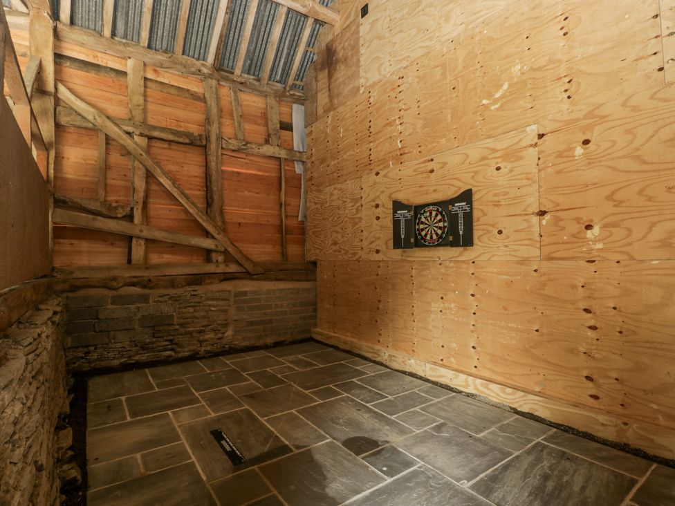 A games room with a dartboard on the wall at Evenjobb Court Farmhouse near Presteigne