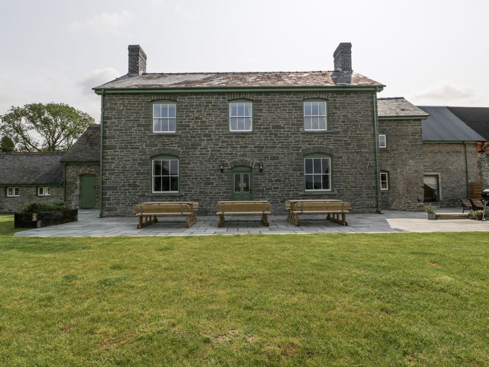 A house with benches and a patio at Evenjobb Court Farmhouse in Evenjobb near Presteigne