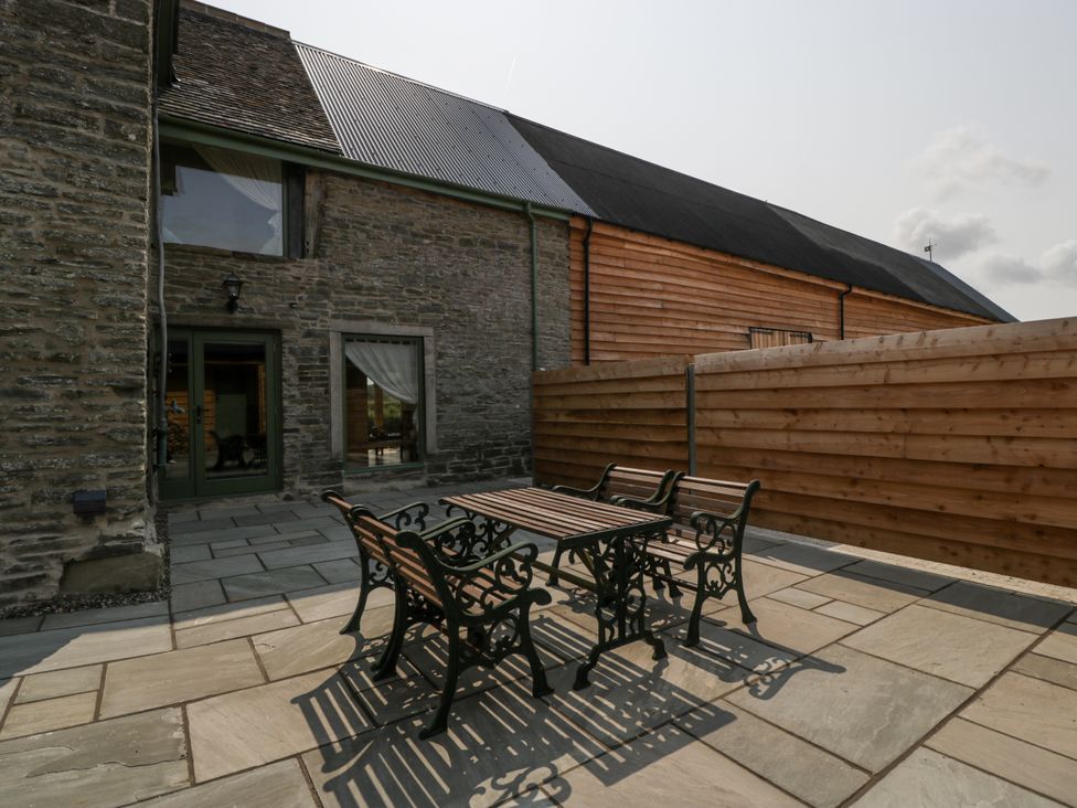 An outdoor area with a table and chairs at Evenjobb Court Farmhouse in Evenjobb near Presteigne