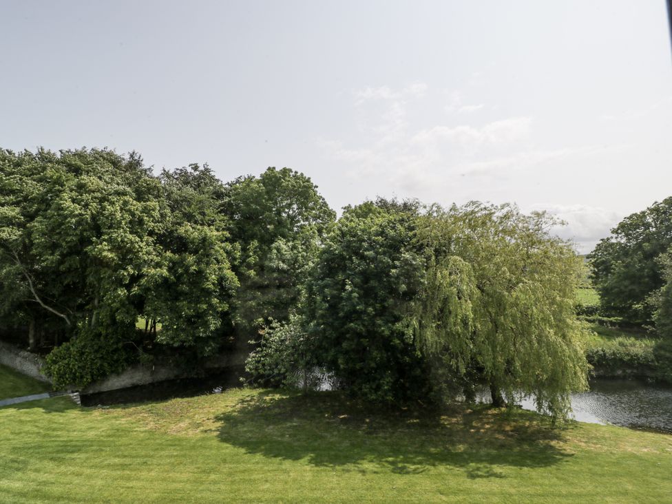 A view of trees and grass next to a river at Evenjobb Court Farmhouse near Presteigne