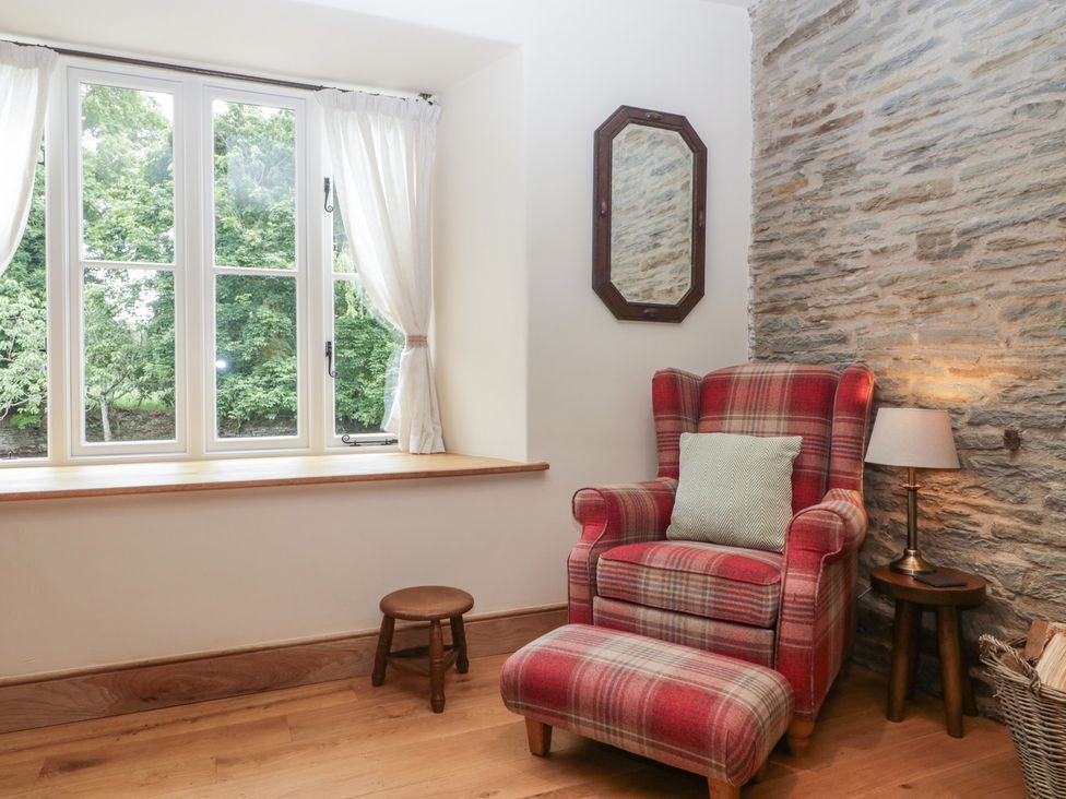 A snug with a window and armchair at Evenjobb Court Farmhouse Evenjobb near Presteigne