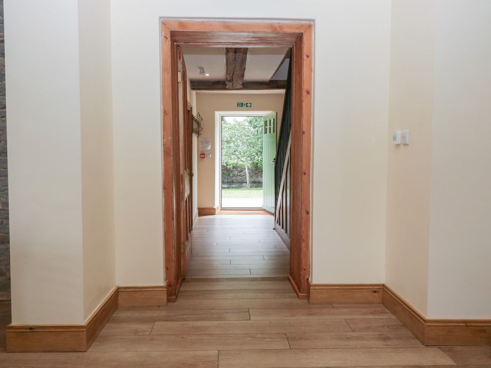 A hallway with a door leading outside at Evenjobb Court Farmhouse near Presteigne