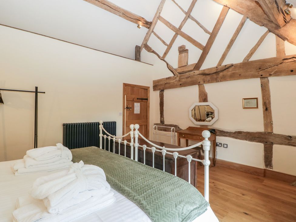A bedroom with a bed and dressing table at Evenjobb Court Farmhouse near Presteigne