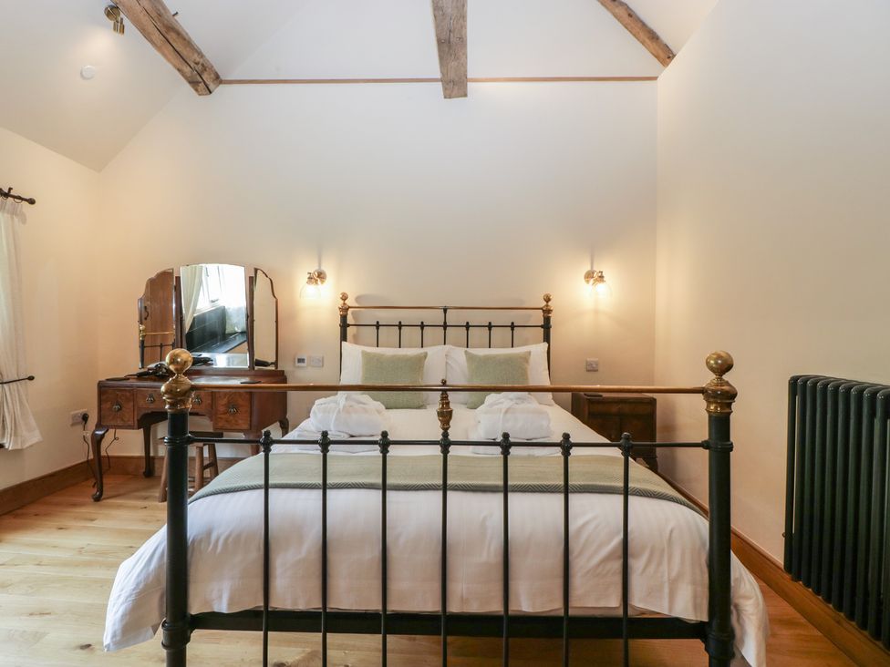 A bedroom with a bed and dresser at Evenjobb Court Farmhouse Evenjobb near Presteigne