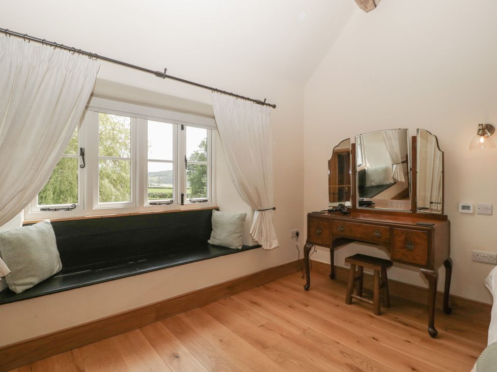 A bedroom with a window seat and vanity at Evenjobb Court Farmhouse near Presteigne
