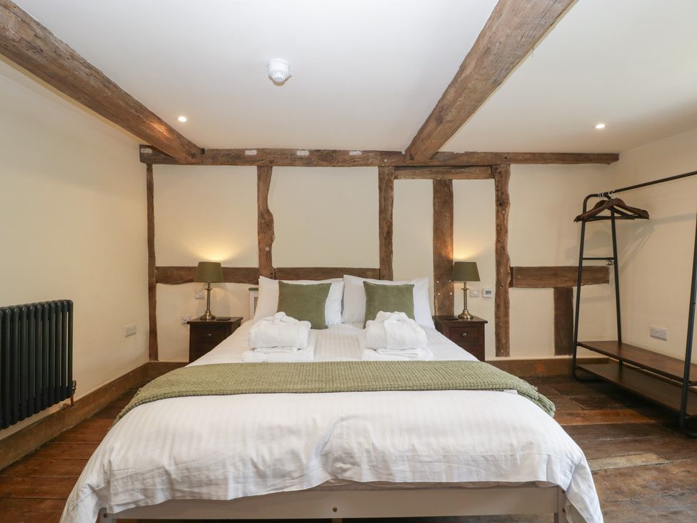 A bedroom with a bed and nightstand at Evenjobb Court Farmhouse Evenjobb near Presteigne