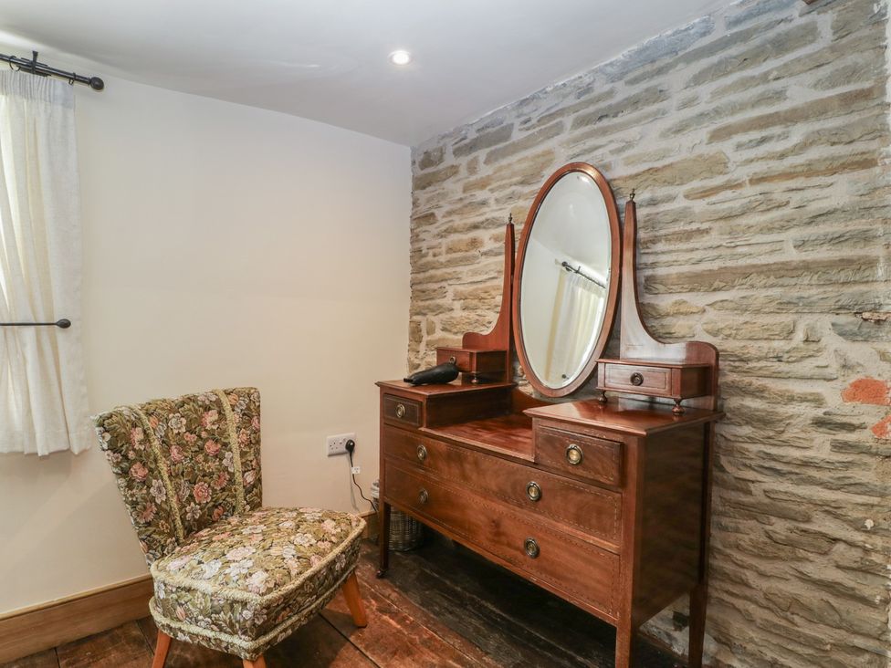 A bedroom with a vanity area at Evenjobb Court Farmhouse Evenjobb near Presteigne