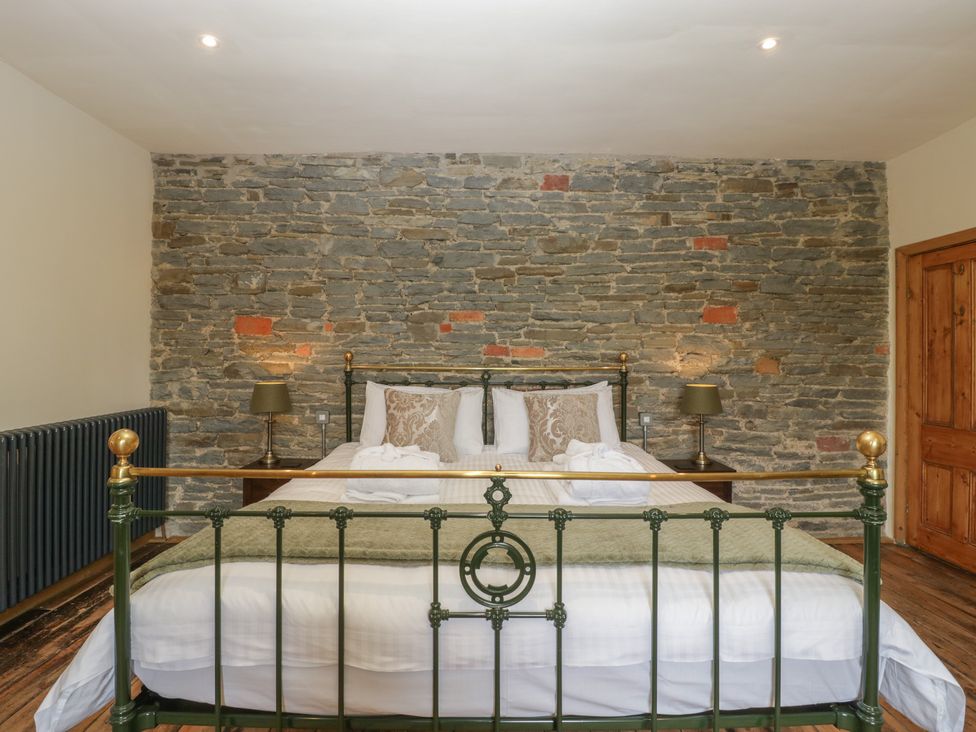 A bedroom with a bed and lamps at Evenjobb Court Farmhouse Evenjobb near Presteigne