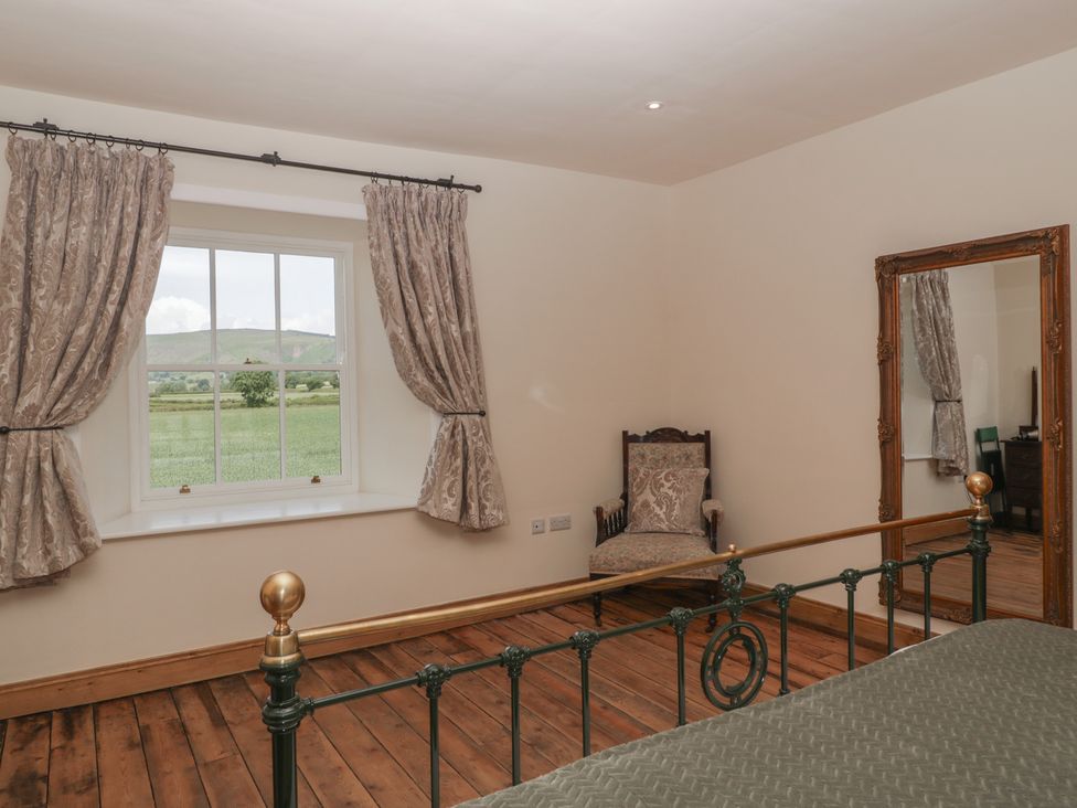 A bedroom with a bed and window at Evenjobb Court Farmhouse near Presteigne