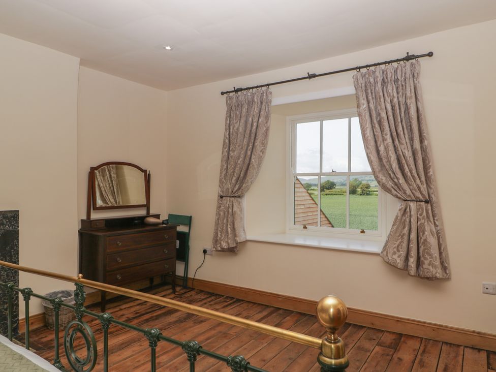 A bedroom with a bed and dresser at Evenjobb Court Farmhouse near Presteigne
