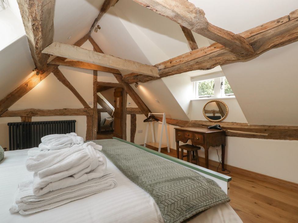 A bedroom with wooden beams and a bed at Evenjobb Court Farmhouse Evenjobb near Presteigne