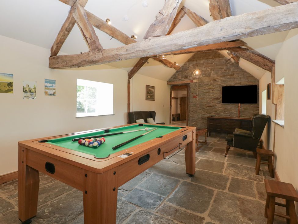 A game room with a billiards table and seating at Evenjobb Court Farmhouse Evenjobb near Presteigne