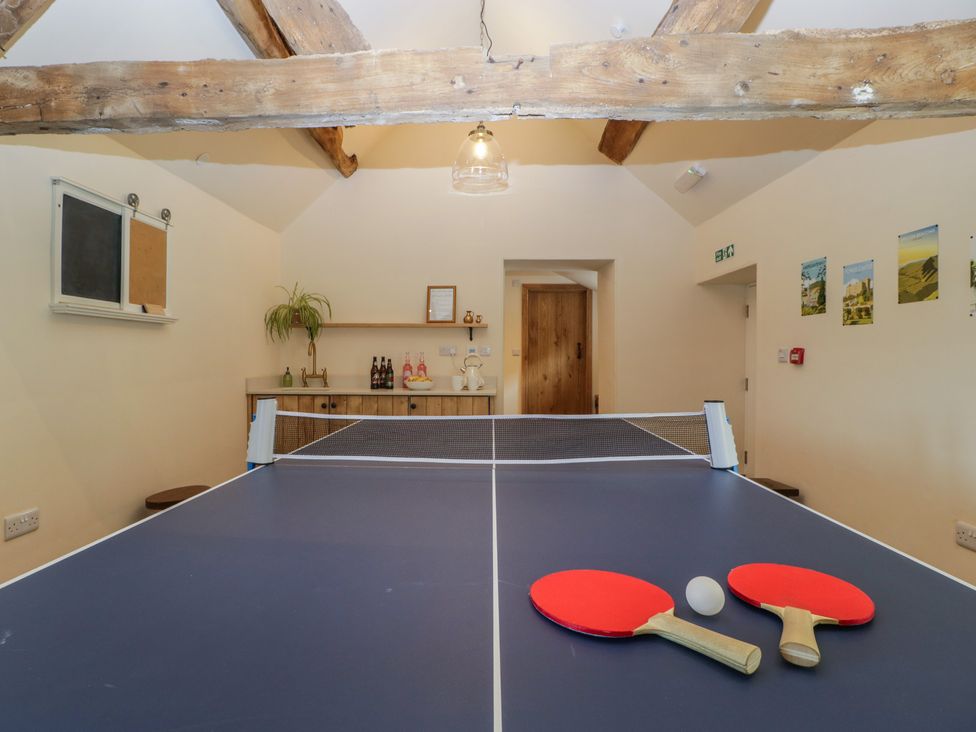 A table tennis table with paddles and a ball at Evenjobb Court Farmhouse Evenjobb near Presteigne
