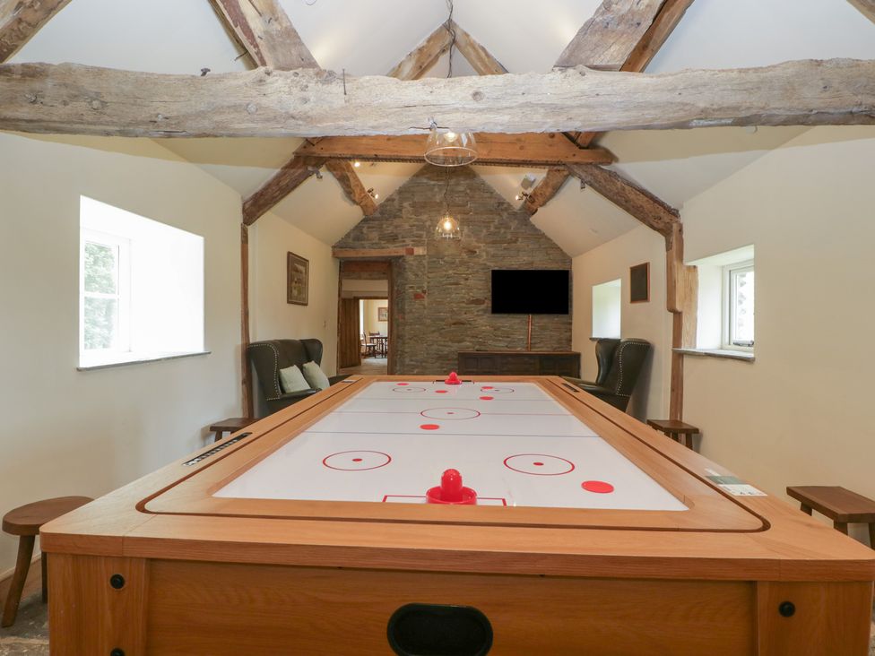 A games room with an air hockey table and chairs at Evenjobb Court Farmhouse in Evenjobb near Presteigne