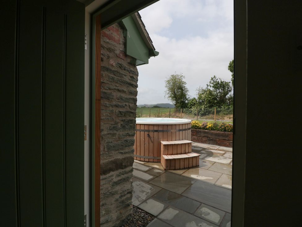 An outdoor view showing a hot tub and patio at Evenjobb Court Farmhouse near Presteigne