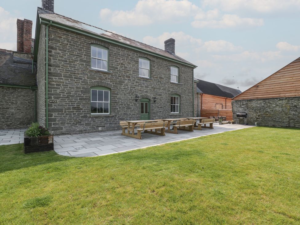 An outdoor patio with benches at Evenjobb Court Farmhouse near Presteigne