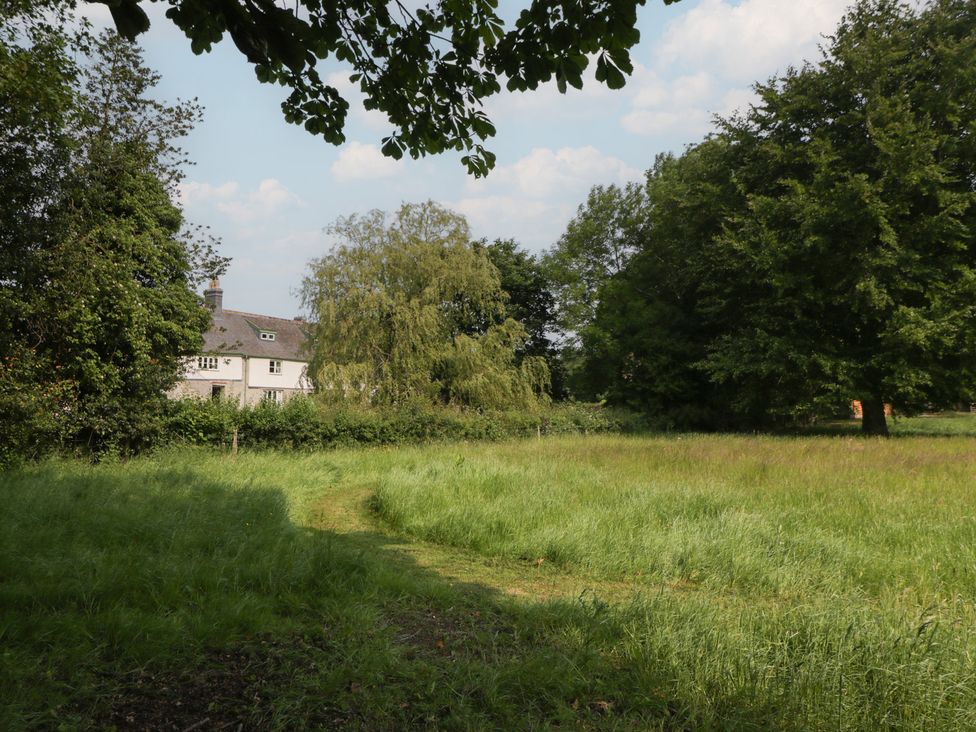 A house surrounded by trees and grass at Evenjobb Court Farmhouse in Evenjobb near Presteigne