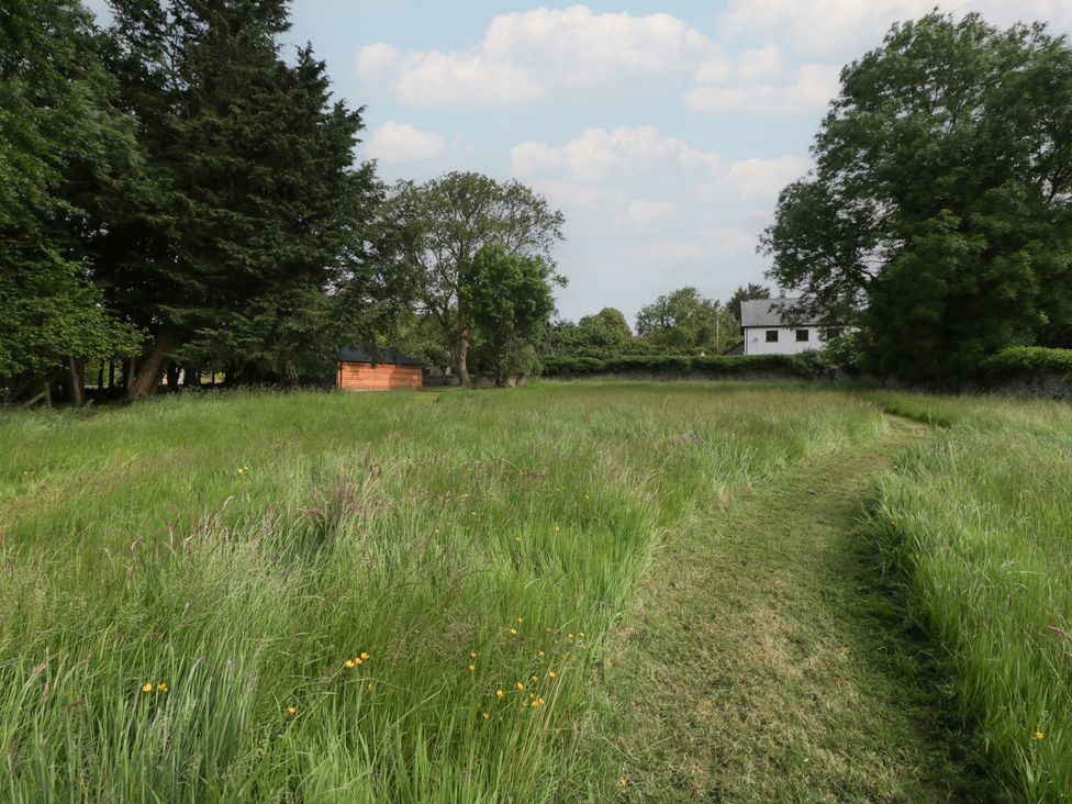 An outdoor area with grass and trees at Evenjobb Court Farmhouse in Evenjobb near Presteigne