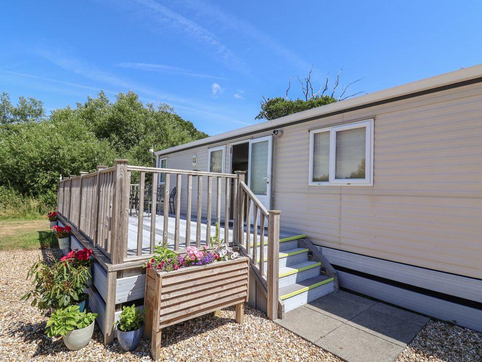 A mobile home with a deck and steps at The Hideaway in Portesham