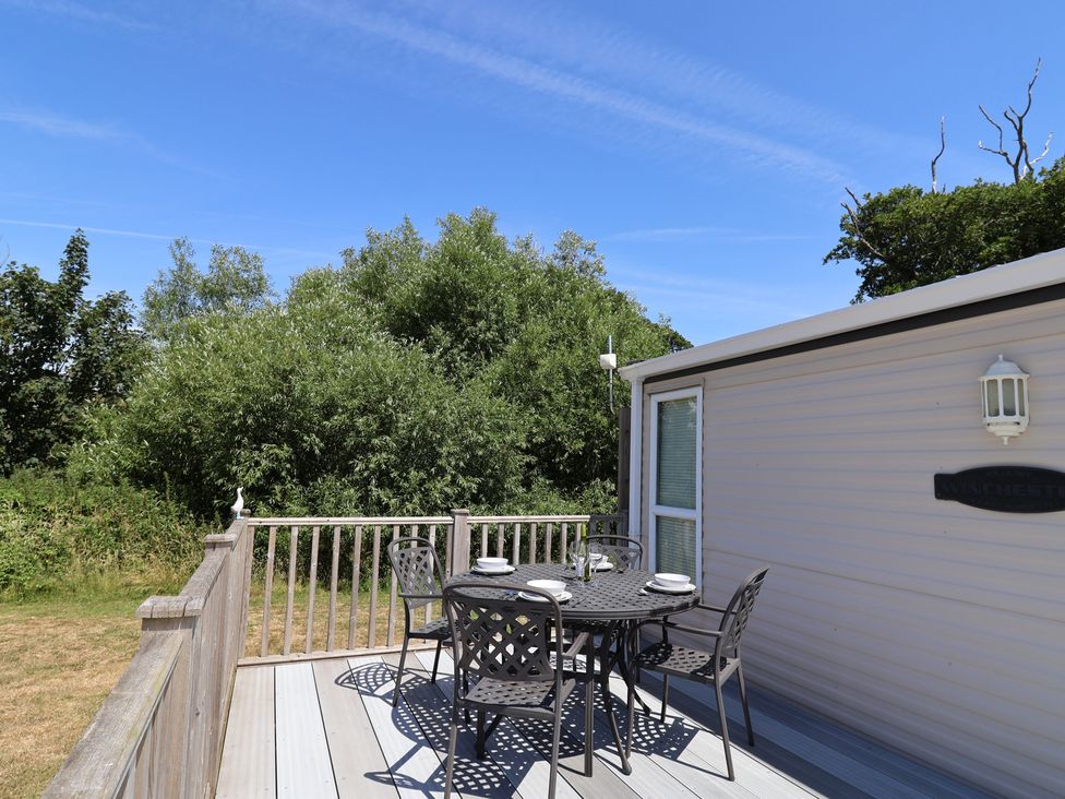 An outdoor deck with a table and chairs at The Hideaway in Portesham