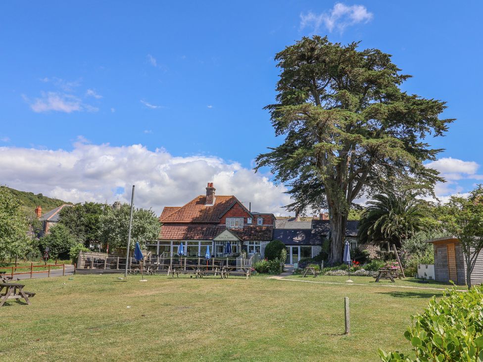 A garden with tables and a building at The Hideaway in Portesham