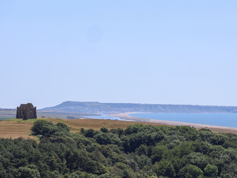 A distant view of a building near a beach and ocean at The Hideaway in Portesham