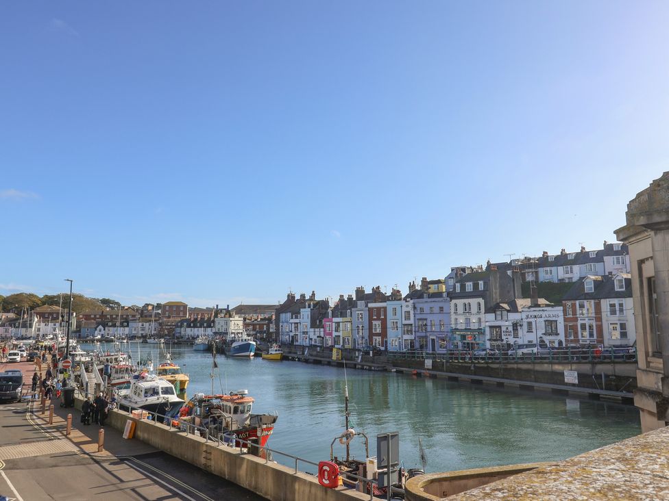 A harbor with boats and buildings alongside the water at The Hideaway in Portesham
