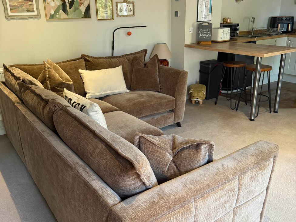 A living room with a sofa and kitchen area at The Annexe in Bridlington