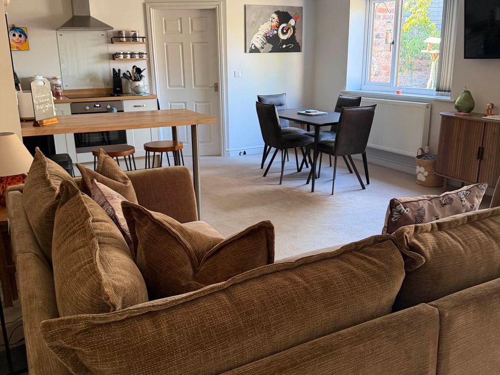 A living room with a sofa and dining area at The Annexe in Bridlington