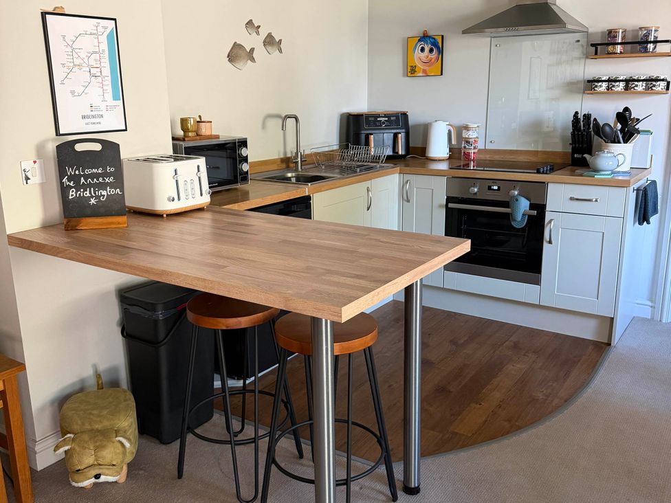 A kitchen with a counter and stools at The Annexe Bridlington